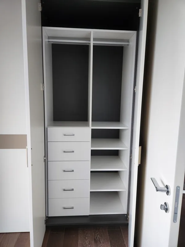 White reach-in closet with four drawers, hanging storage and open shelves